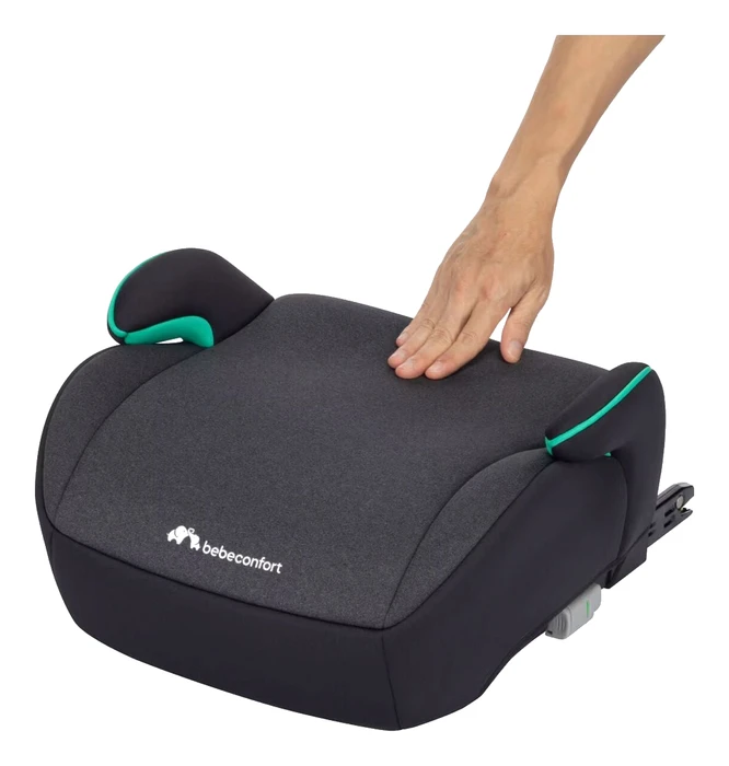 Hand som trycker på Bebeconfort Manga i-Fix sitsyta, visar stoppningens tjocklek och mjukhet